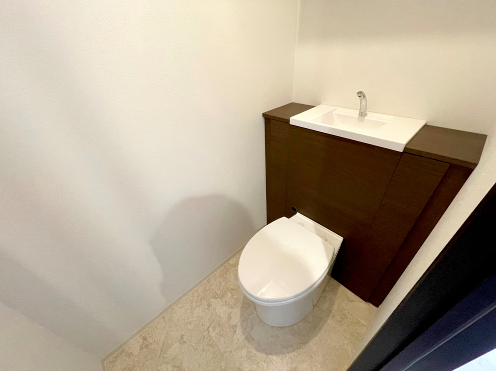 Idées déco pour un WC et toilettes moderne de taille moyenne avec WC à poser, un mur blanc, un sol en vinyl, un lavabo intégré, un sol beige, un plafond en papier peint et du papier peint.
