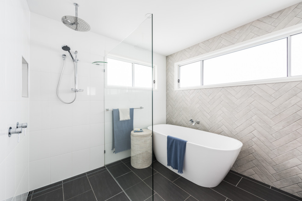 Inspiration for a beach style bathroom in Gold Coast - Tweed with a freestanding tub, a curbless shower, gray tile, black floor and an open shower.