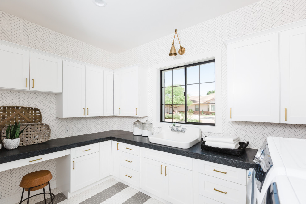 Inspiration for a transitional u-shaped dedicated laundry room in Phoenix with a drop-in sink, shaker cabinets, white cabinets, mosaic tile splashback, a side-by-side washer and dryer, multi-coloured floor and black benchtop.