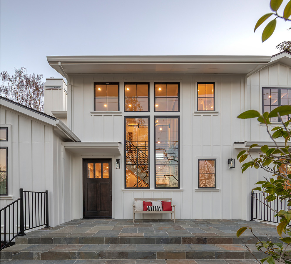 Small country two-storey white house exterior in San Francisco with wood siding, a gable roof and a shingle roof.