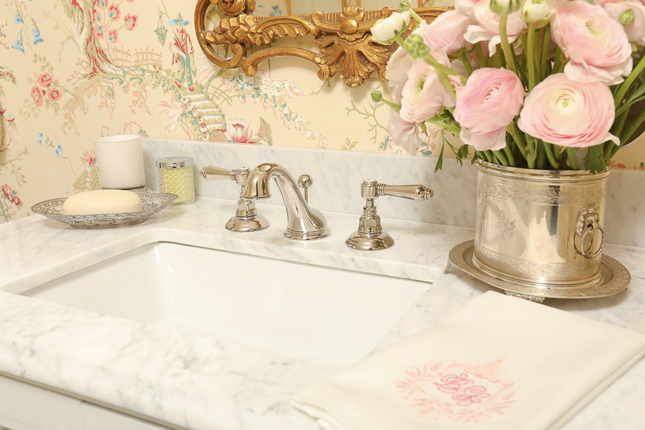 Inspiration for a small traditional powder room in Atlanta with glass-front cabinets, white cabinets, a two-piece toilet, white tile, pink walls, marble floors, an undermount sink and marble benchtops.