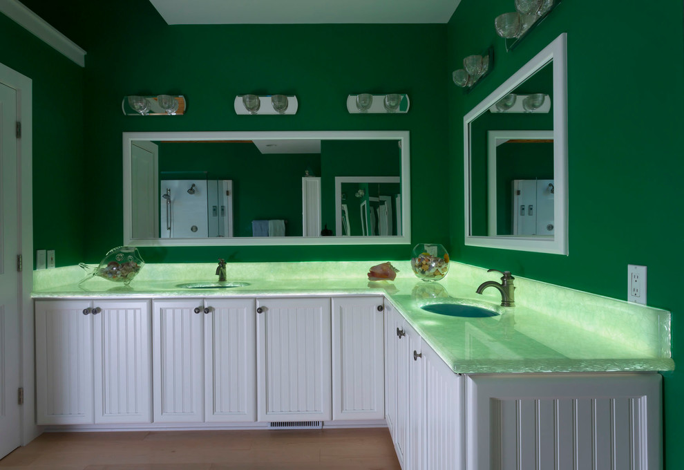 Inspiration for a large beach style master bathroom in Charlotte with beaded inset cabinets, white cabinets, a freestanding tub, a corner shower, stone slab, green walls, light hardwood floors, an undermount sink, onyx benchtops and green benchtops.