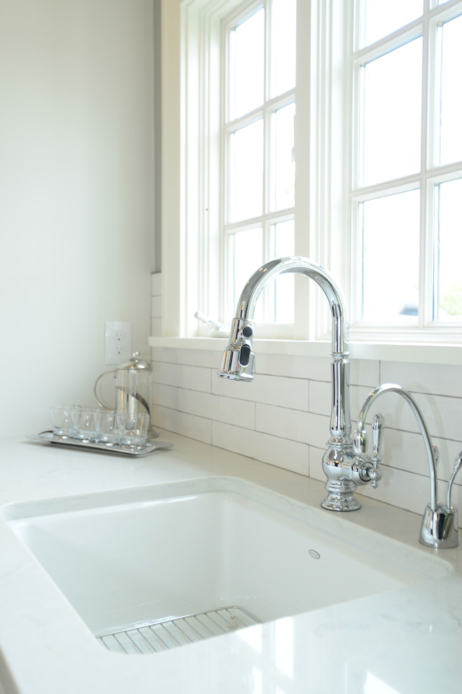Large transitional single-wall medium tone wood floor eat-in kitchen photo in Seattle with an undermount sink, shaker cabinets, white cabinets, quartz countertops, white backsplash, subway tile backsplash, paneled appliances and an island