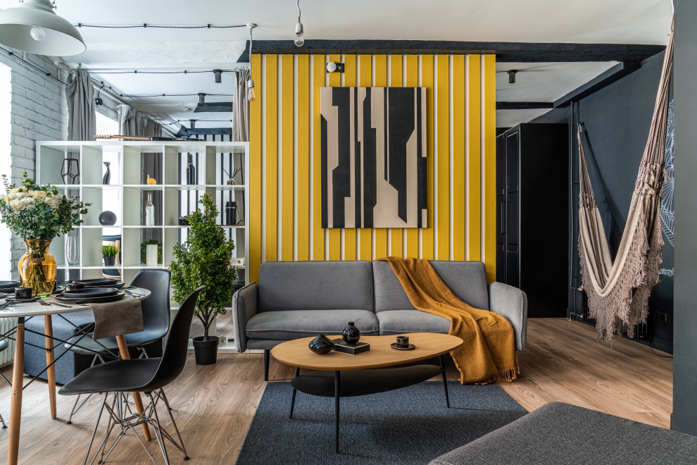 Идея дизайна: маленькая гостиная комната в скандинавском стиле с желтыми стенами, зоной отдыха, бежевым полом, балками на потолке, деревянными стенами, акцентной стеной и полом из ламината для на участке и в саду