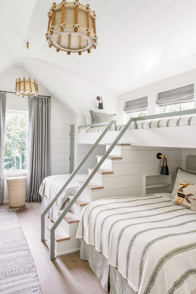 Small beach style gender-neutral kids' bedroom in Charleston with white walls, light hardwood floors, timber, vaulted and planked wall panelling.
