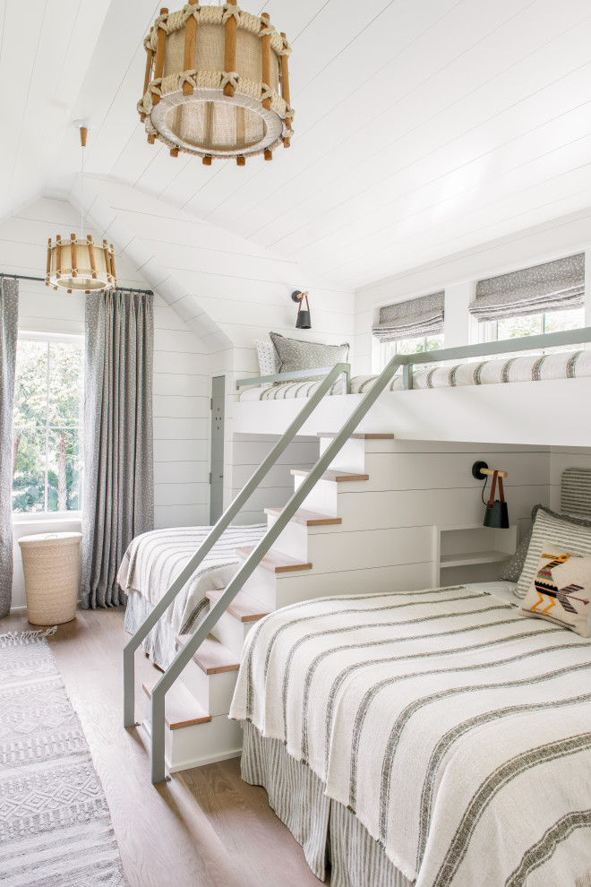 Sullivan's Island Remodel - Bunk bedroom featuring custom built-in bunk beds with white oak stair treads painted railing, niches with outlets and lighting, custom drapery and decorative lighting