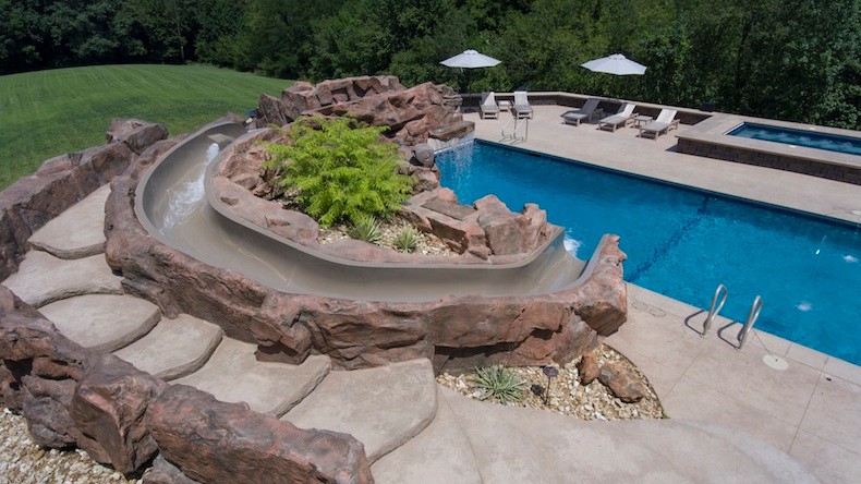 Photo of a large transitional backyard rectangular lap pool in Cedar Rapids with a water slide and concrete pavers.