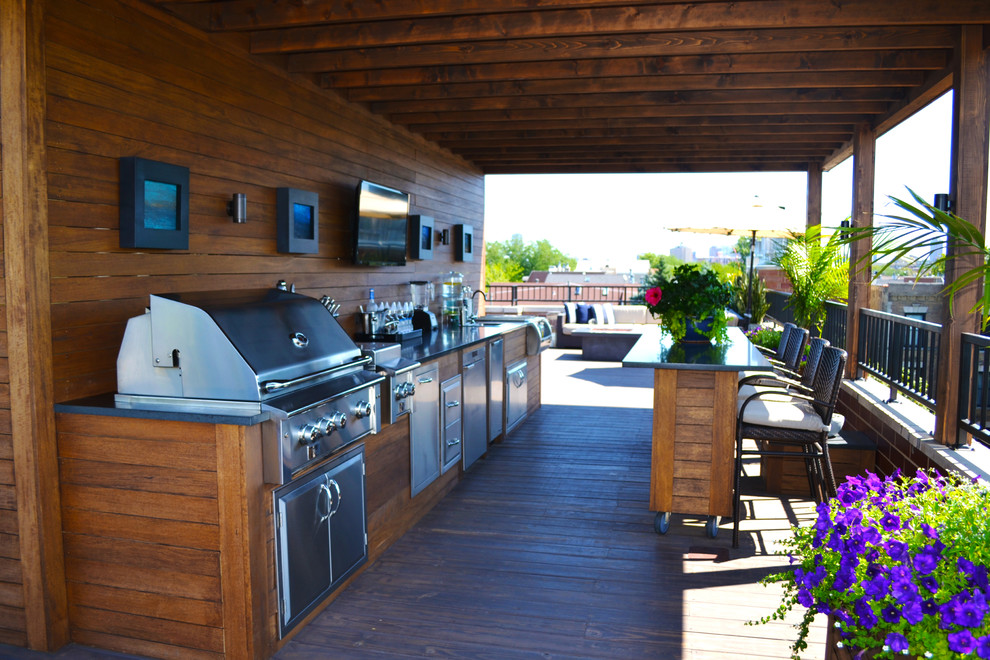 Photo of a mid-sized contemporary rooftop deck in Chicago with an outdoor kitchen and an awning.