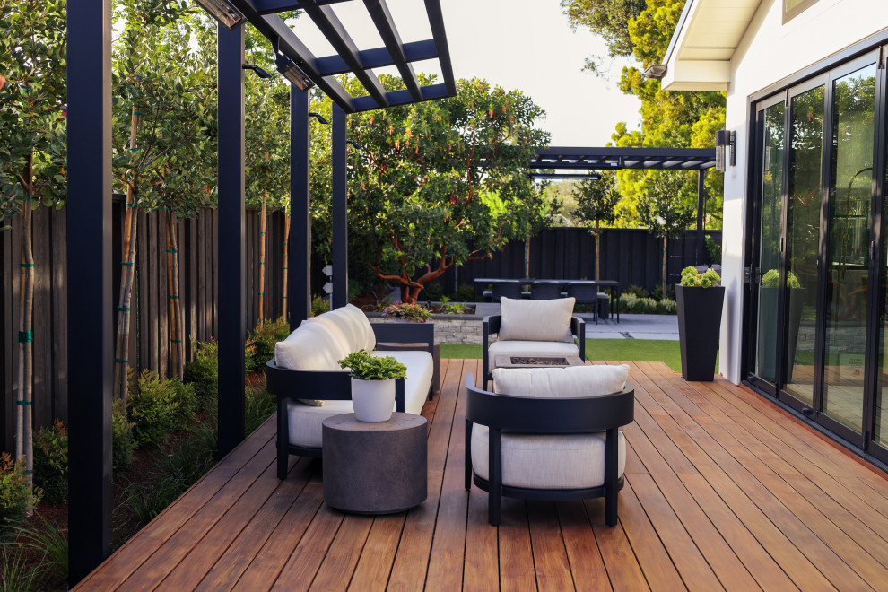 This is an example of a contemporary back ground level terrace in San Francisco with a fire feature and a pergola.
