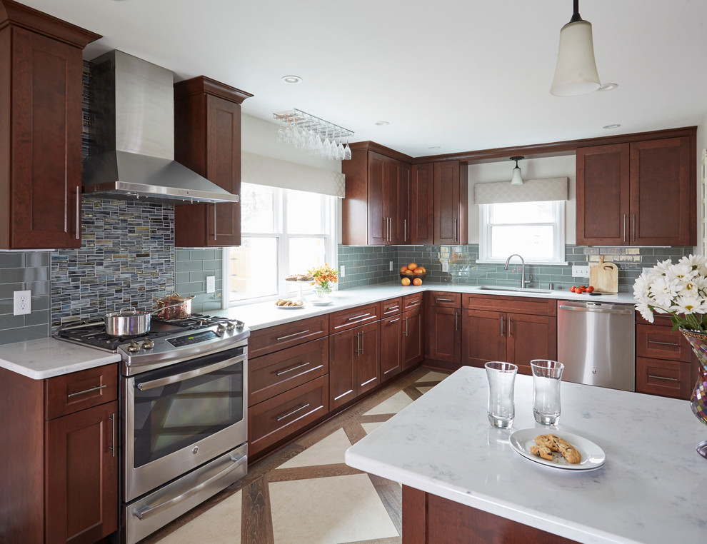 Inspiration for a mid-sized transitional l-shaped eat-in kitchen in Milwaukee with an undermount sink, shaker cabinets, medium wood cabinets, quartzite benchtops, blue splashback, glass tile splashback, stainless steel appliances, ceramic floors and a peninsula.