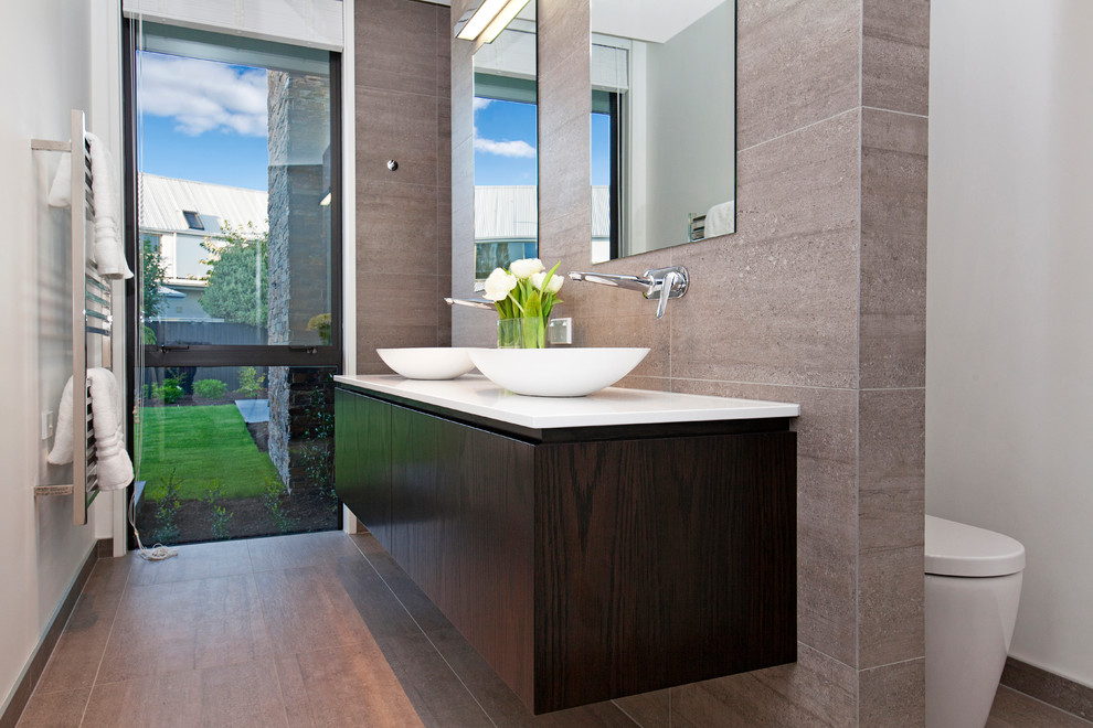 Inspiration for a small contemporary 3/4 bathroom in Christchurch with dark wood cabinets, an open shower, a one-piece toilet, brown tile, ceramic tile, white walls, ceramic floors, a vessel sink, engineered quartz benchtops, brown floor, an open shower and white benchtops.