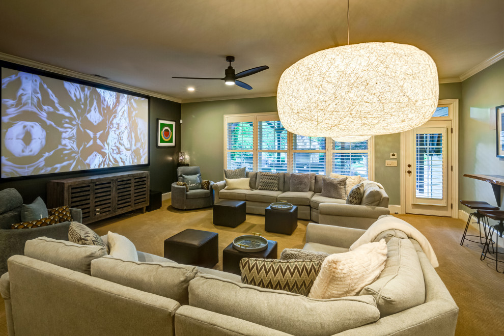 Expansive contemporary enclosed home theatre in Raleigh with green walls, carpet, a projector screen and beige floor.