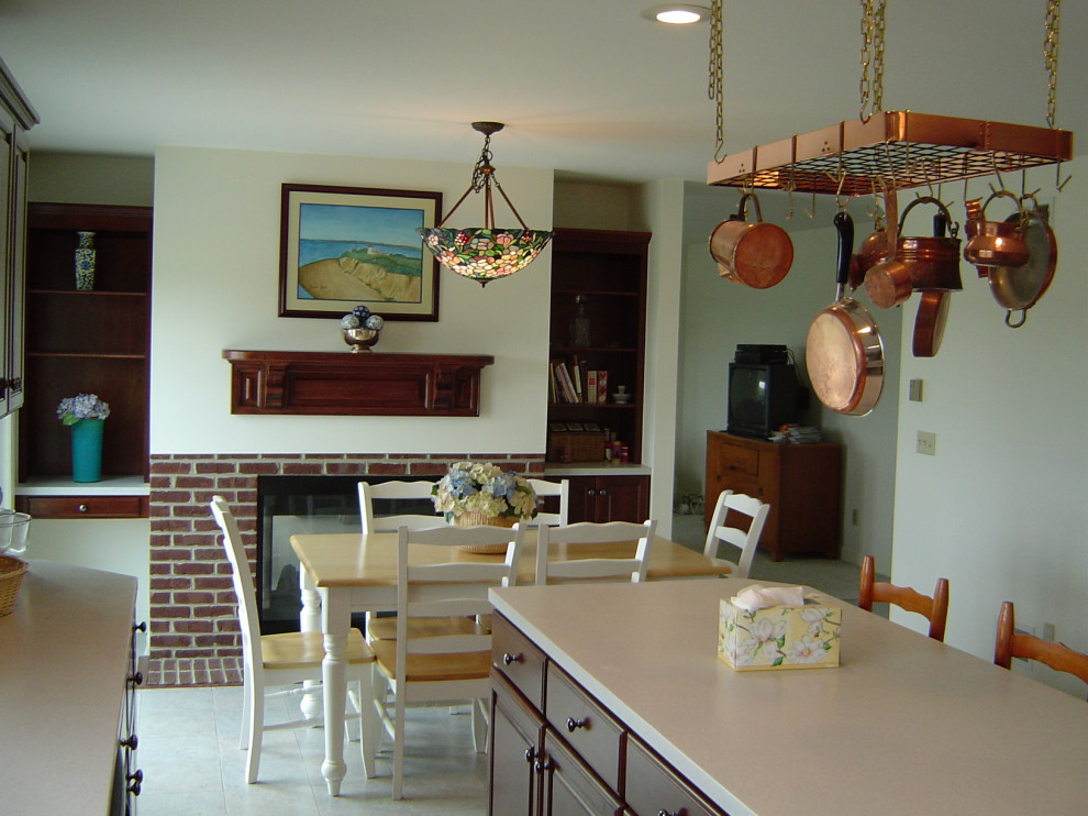 Inspiration for a l-shaped ceramic tile and beige floor kitchen remodel with recessed-panel cabinets, dark wood cabinets, black appliances, an island and white countertops