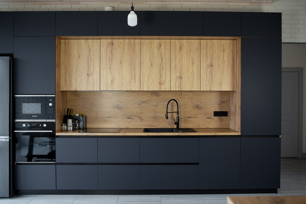 Inspiration for a large industrial grey and white single-wall kitchen/diner in Other with a submerged sink, flat-panel cabinets, black cabinets, laminate countertops, brown splashback, all types of splashback, black appliances, laminate floors, an island, beige floors, brown worktops and a timber clad ceiling.