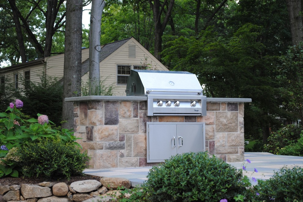 Photo of a large traditional backyard patio in New York with an outdoor kitchen, tile and no cover.