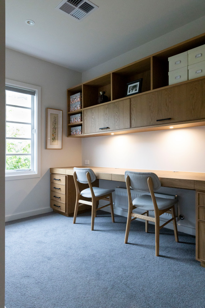 Cette image montre un grand bureau design avec un mur blanc, moquette, aucune cheminée, un bureau intégré et un sol gris.