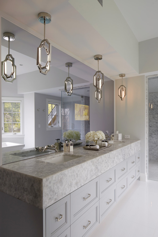 Design ideas for a large transitional master bathroom in New York with recessed-panel cabinets, grey cabinets, a freestanding tub, an alcove shower, gray tile, marble, grey walls, porcelain floors, an undermount sink, soapstone benchtops, white floor and a hinged shower door.