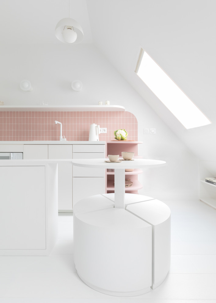 Inredning av ett modernt litet vit linjärt vitt kök och matrum, med en enkel diskho, luckor med profilerade fronter, vita skåp, laminatbänkskiva, rosa stänkskydd, stänkskydd i keramik, vita vitvaror, målat trägolv, en köksö och vitt golv