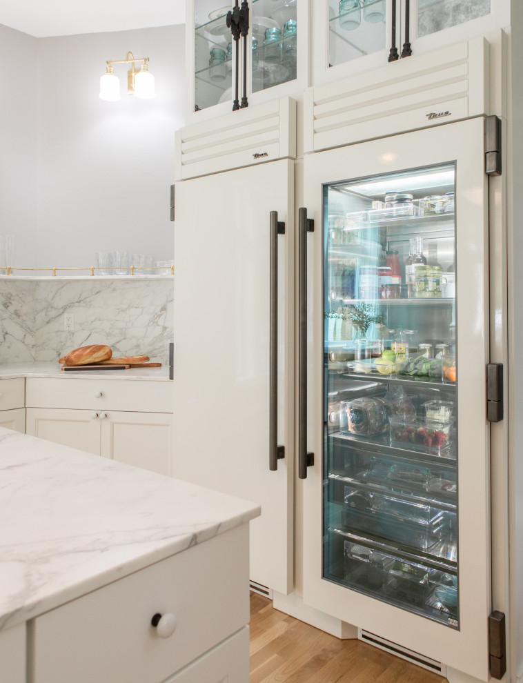 Exempel på ett mellanstort vit vitt kök, med en rustik diskho, luckor med glaspanel, gula skåp, marmorbänkskiva, vitt stänkskydd, stänkskydd i porslinskakel, vita vitvaror, mellanmörkt trägolv, en köksö och brunt golv