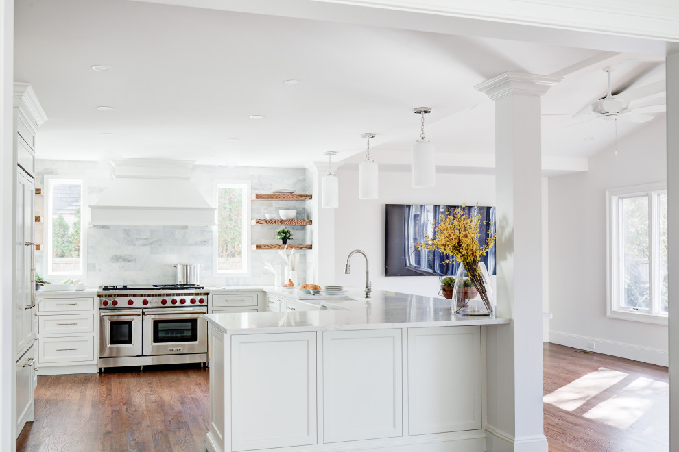 Mid-sized transitional u-shaped medium tone wood floor and brown floor open concept kitchen photo with a farmhouse sink, recessed-panel cabinets, white cabinets, quartz countertops, multicolored backsplash, marble backsplash, stainless steel appliances, a peninsula and white countertops
