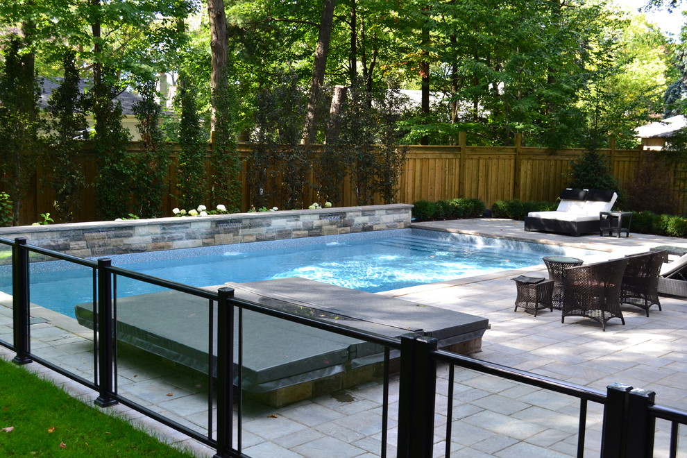 Large transitional backyard tile and rectangular lap hot tub photo in Toronto