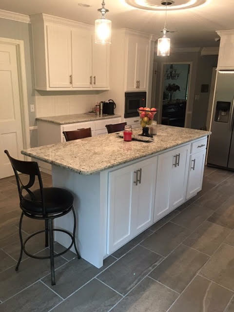 Example of a large transitional u-shaped gray floor eat-in kitchen design in Birmingham with shaker cabinets, white cabinets, white backsplash, stainless steel appliances, an island and a double-bowl sink