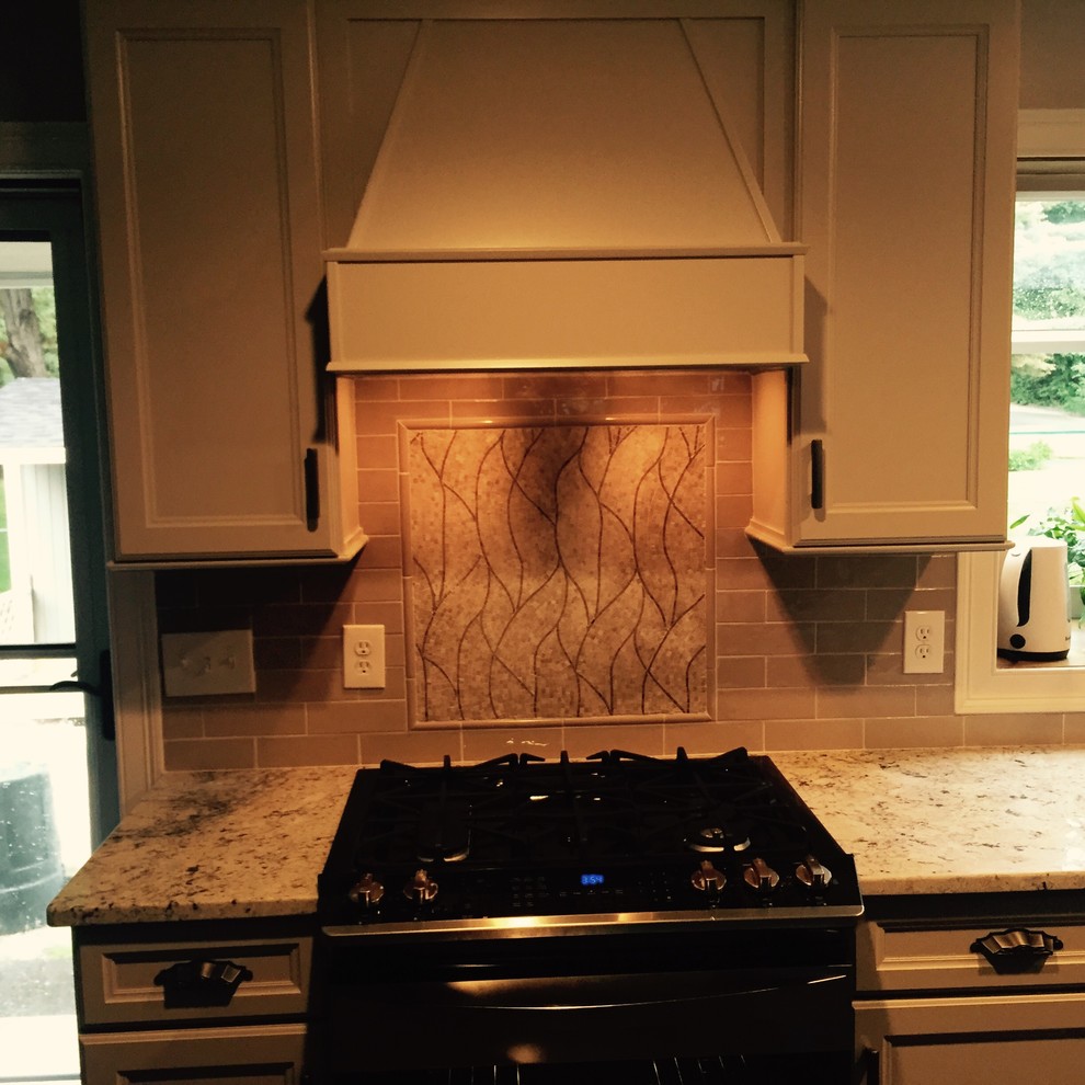 Kitchen - mid-sized transitional kitchen idea in Boston with recessed-panel cabinets, gray cabinets, granite countertops, beige backsplash, mosaic tile backsplash and stainless steel appliances