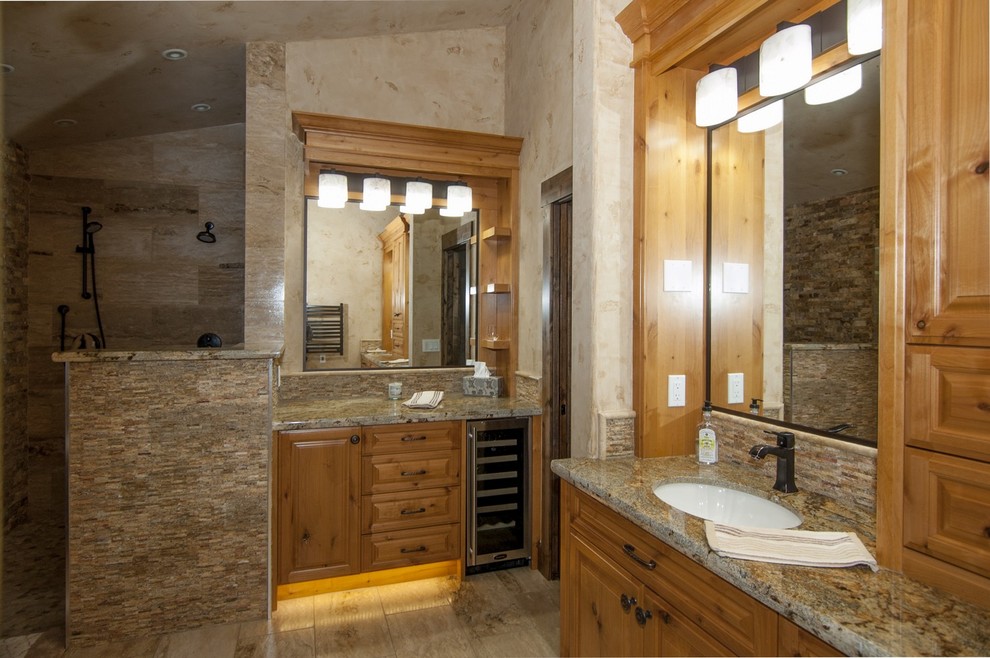Mid-sized transitional stone tile freestanding bathtub photo with an undermount sink, raised-panel cabinets, medium tone wood cabinets, granite countertops and a two-piece toilet