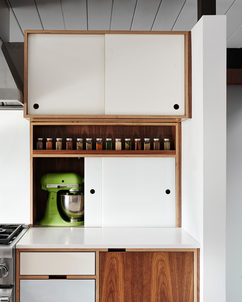 Inspiration for a midcentury galley eat-in kitchen in San Francisco with an undermount sink, flat-panel cabinets, medium wood cabinets, quartz benchtops, stainless steel appliances, vinyl floors, with island, white floor and white benchtop.