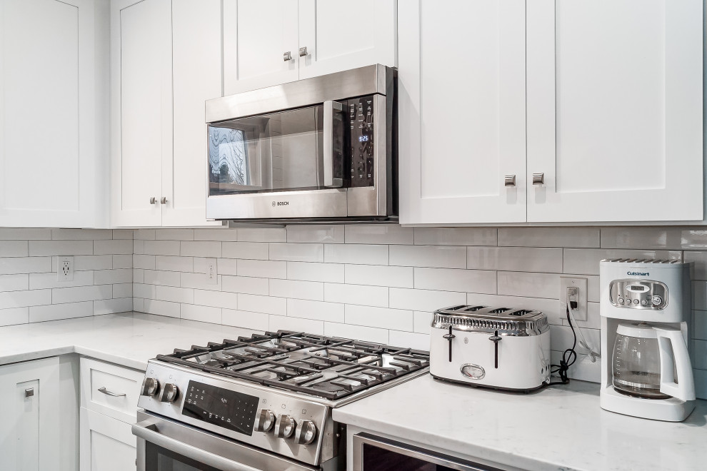 Mid-sized transitional l-shaped eat-in kitchen photo in Columbus with shaker cabinets, quartz countertops, white backsplash, subway tile backsplash and an island