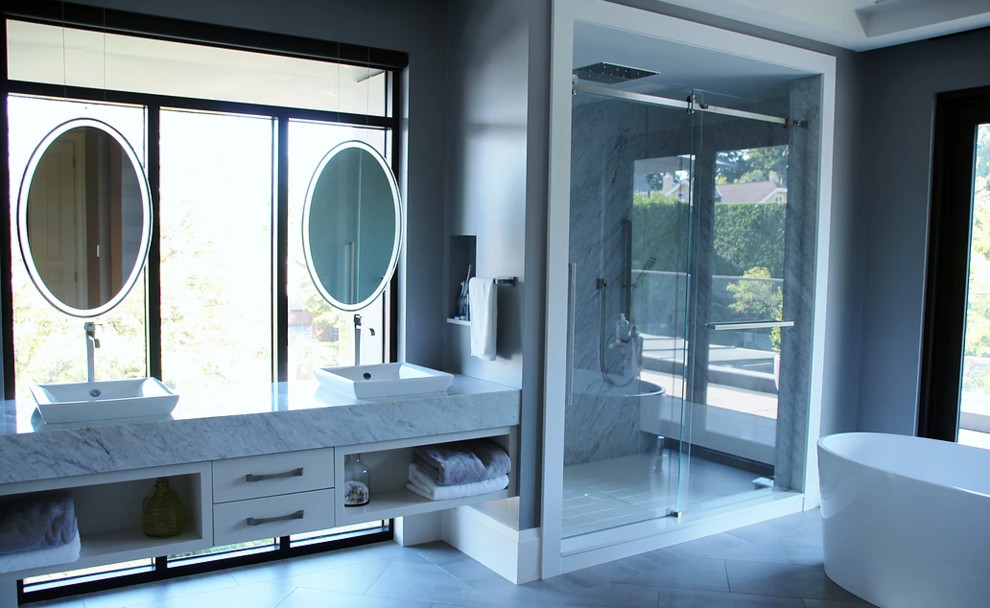 Large contemporary master bathroom in Vancouver with white cabinets, a freestanding tub, a corner shower and a sliding shower screen.