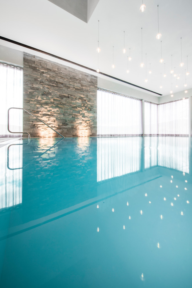 Inspiration for a contemporary indoor custom-shaped pool in Frankfurt with natural stone pavers.