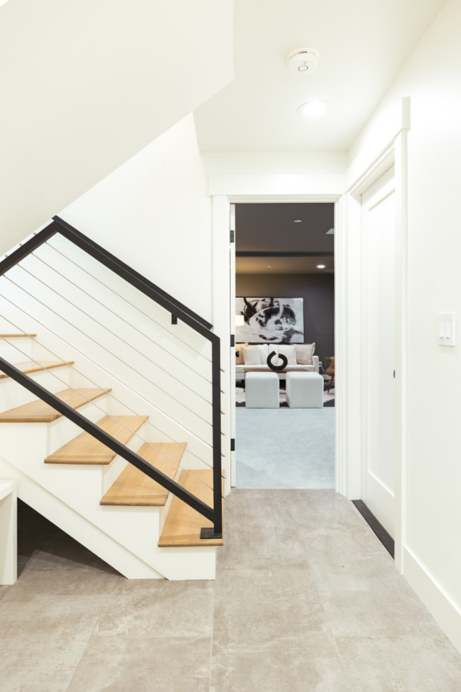 Imagen de escalera en U clásica renovada con escalones de madera, contrahuellas de madera pintada y barandilla de cable