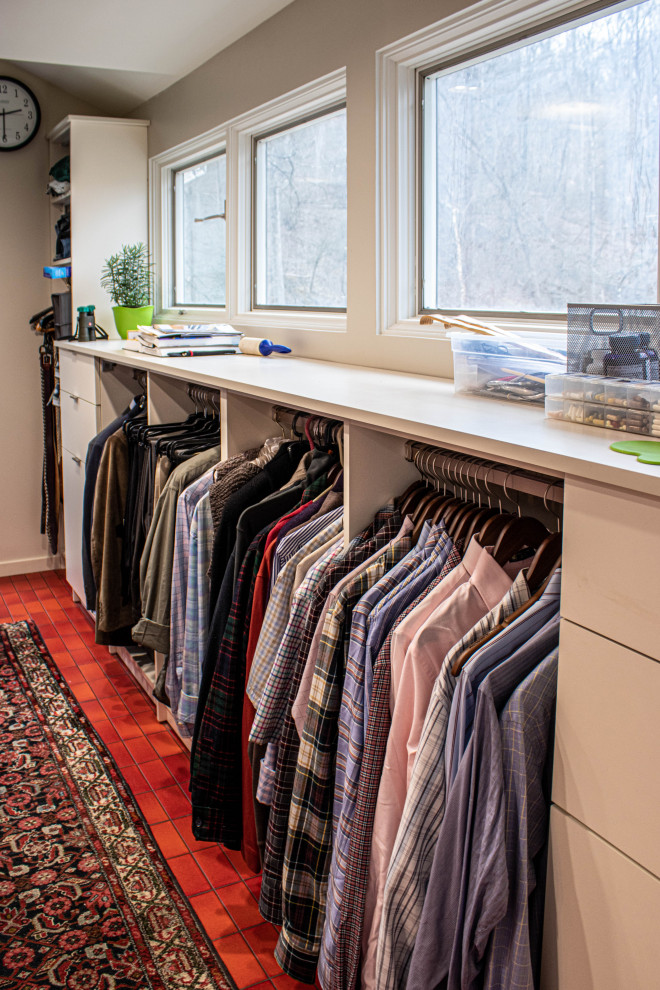 This is an example of a mid-sized midcentury gender-neutral walk-in wardrobe in Cleveland with flat-panel cabinets, white cabinets, ceramic floors and red floor.