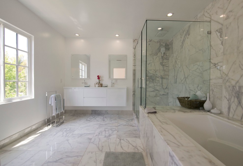 Contemporary bathroom in Los Angeles with flat-panel cabinets, white cabinets, an undermount tub, an alcove shower, white tile, marble floors and marble.