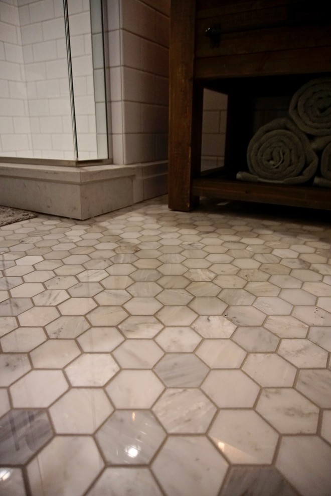 Small transitional 3/4 white tile and subway tile marble floor corner shower photo in Indianapolis with medium tone wood cabinets, a two-piece toilet, blue walls, an undermount sink and marble countertops