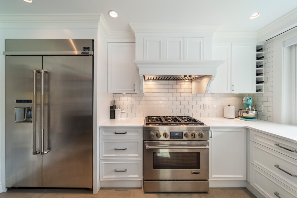 Kitchen - transitional beige floor kitchen idea in Vancouver with white backsplash, stainless steel appliances, an island and white countertops