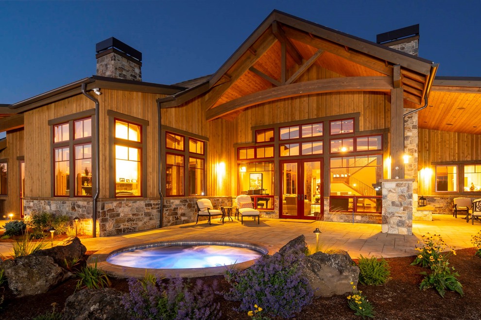 Patio - large rustic backyard stone patio idea with a fireplace and a roof extension