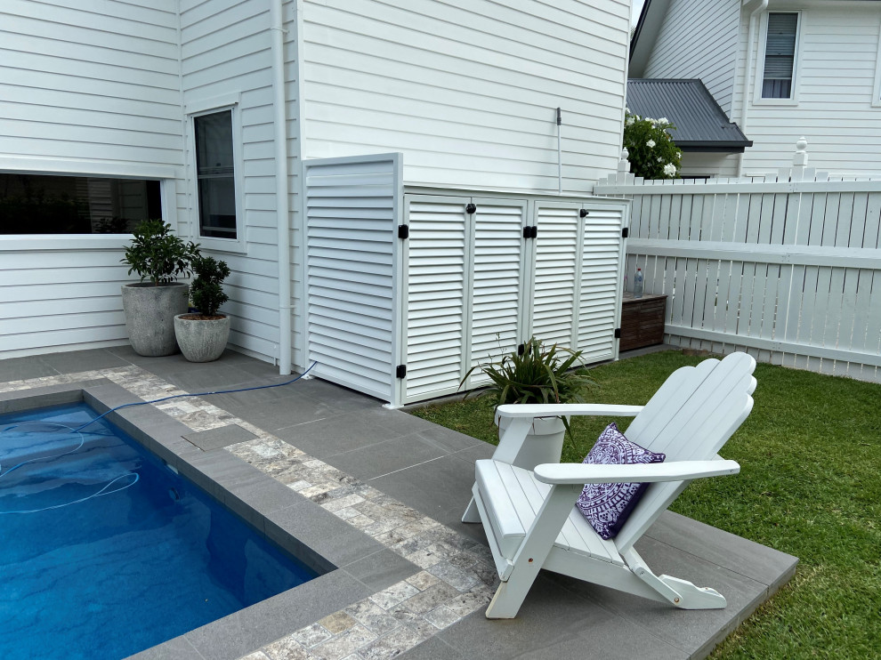 Foto de piscina elevada actual de tamaño medio en patio trasero con paisajismo de piscina