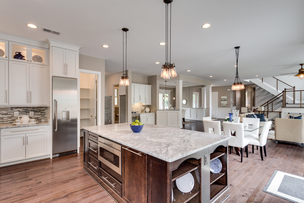 Example of a large transitional u-shaped dark wood floor open concept kitchen design in DC Metro with an undermount sink, shaker cabinets, white cabinets, granite countertops, glass tile backsplash and an island