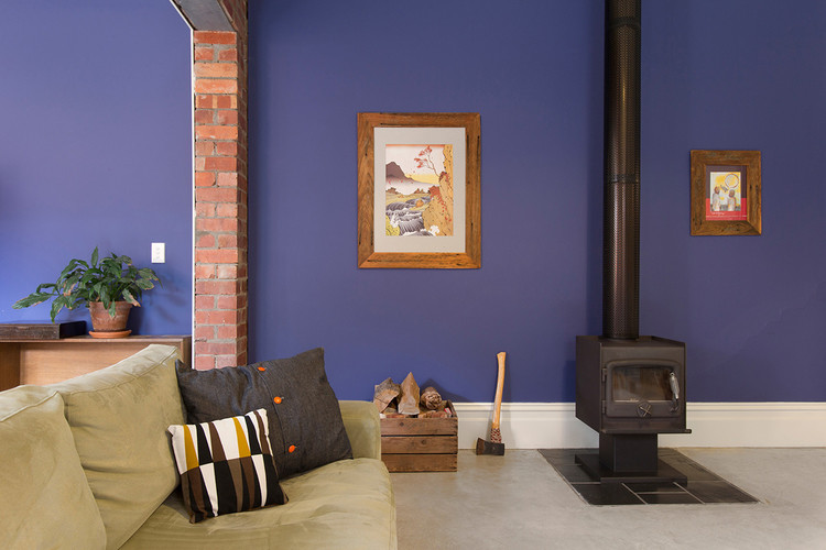 Design ideas for a small contemporary open concept living room in Melbourne with blue walls, a wood stove and concrete floors.