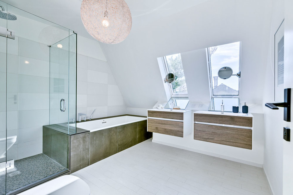 This is an example of a small contemporary bathroom in Toronto with flat-panel cabinets, medium wood cabinets, a drop-in tub, a wall-mount toilet, black and white tile, ceramic tile, white walls, ceramic floors, a wall-mount sink, laminate benchtops, a corner shower and a hinged shower door.