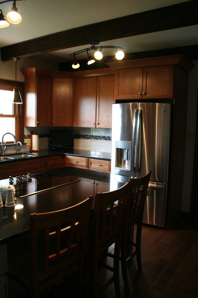 Kitchen - mid-sized transitional l-shaped medium tone wood floor kitchen idea with an undermount sink, medium tone wood cabinets, granite countertops, white backsplash, subway tile backsplash, stainless steel appliances, an island and recessed-panel cabinets