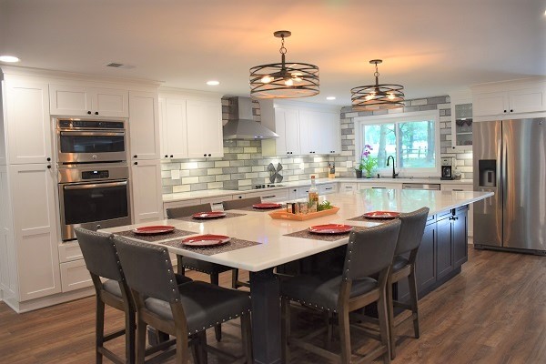 Open concept kitchen - large transitional l-shaped medium tone wood floor open concept kitchen idea in Baltimore with a single-bowl sink, shaker cabinets, white cabinets, quartz countertops, gray backsplash, subway tile backsplash, stainless steel appliances, an island and white countertops