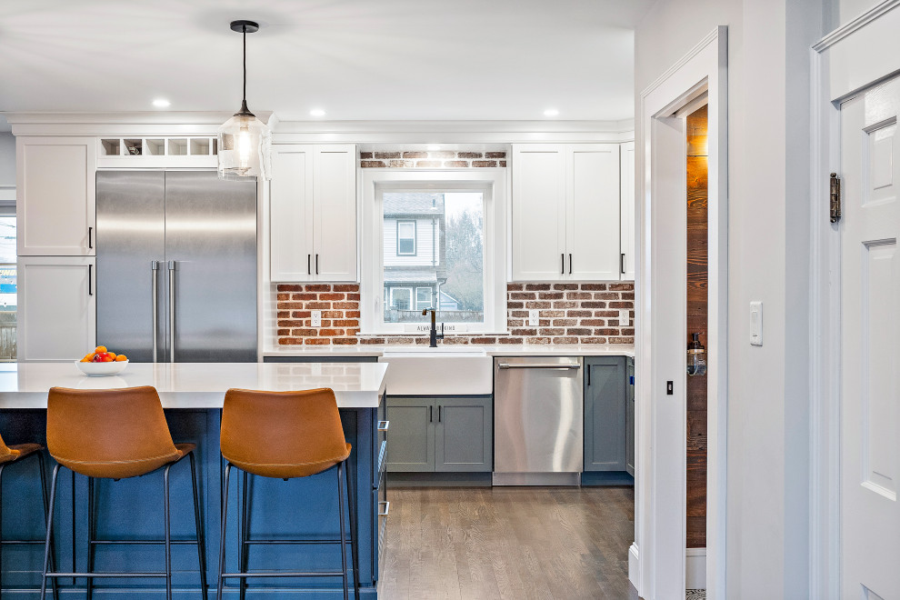 Eat-in kitchen - mid-sized rustic l-shaped dark wood floor eat-in kitchen idea in Boston with a farmhouse sink, shaker cabinets, quartz countertops, red backsplash, brick backsplash, stainless steel appliances, an island and white countertops