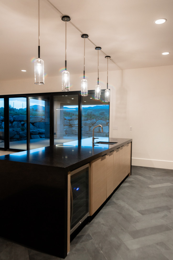 Design ideas for a mid-sized contemporary galley wet bar in Salt Lake City with an undermount sink, flat-panel cabinets, brown cabinets, quartz benchtops, brown splashback, timber splashback, slate floors, black floor and black benchtop.
