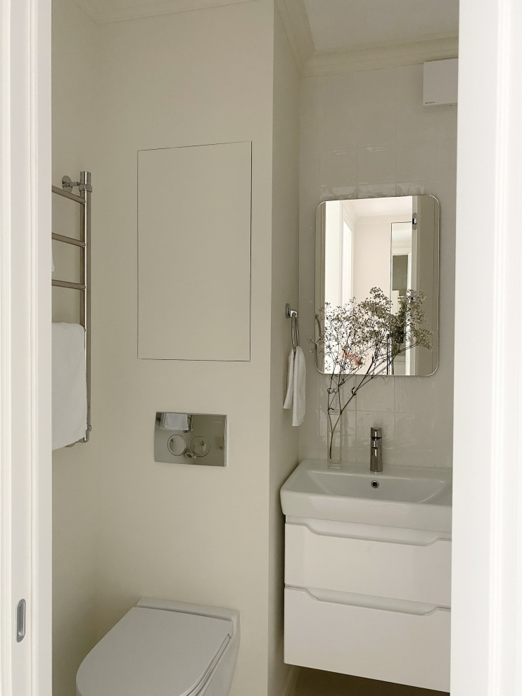 Свежая идея для дизайна: маленькая главная ванная комната в современном стиле с плоскими фасадами, белыми фасадами, инсталляцией, белой плиткой, керамической плиткой, бежевыми стенами, полом из керамогранита, накладной раковиной, бежевым полом, зеркалом с подсветкой, тумбой под одну раковину и подвесной тумбой для на участке и в саду - отличное фото интерьера