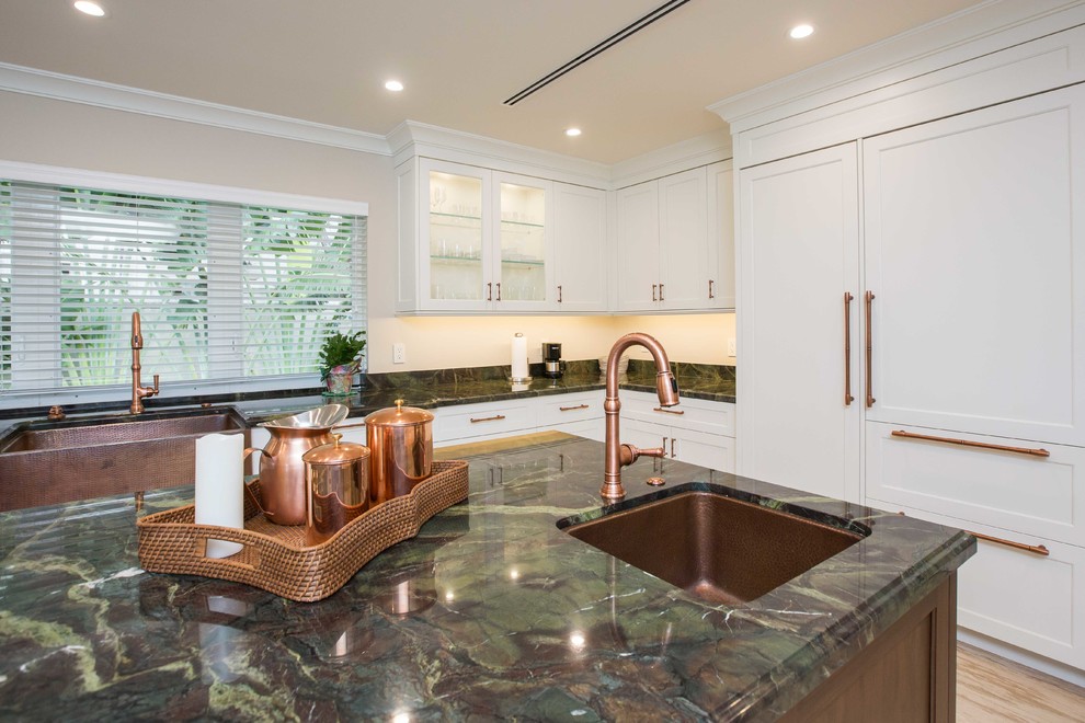 Example of a large transitional u-shaped light wood floor open concept kitchen design in Miami with a farmhouse sink, shaker cabinets, stainless steel appliances, an island, white cabinets, granite countertops, metallic backsplash and mosaic tile backsplash