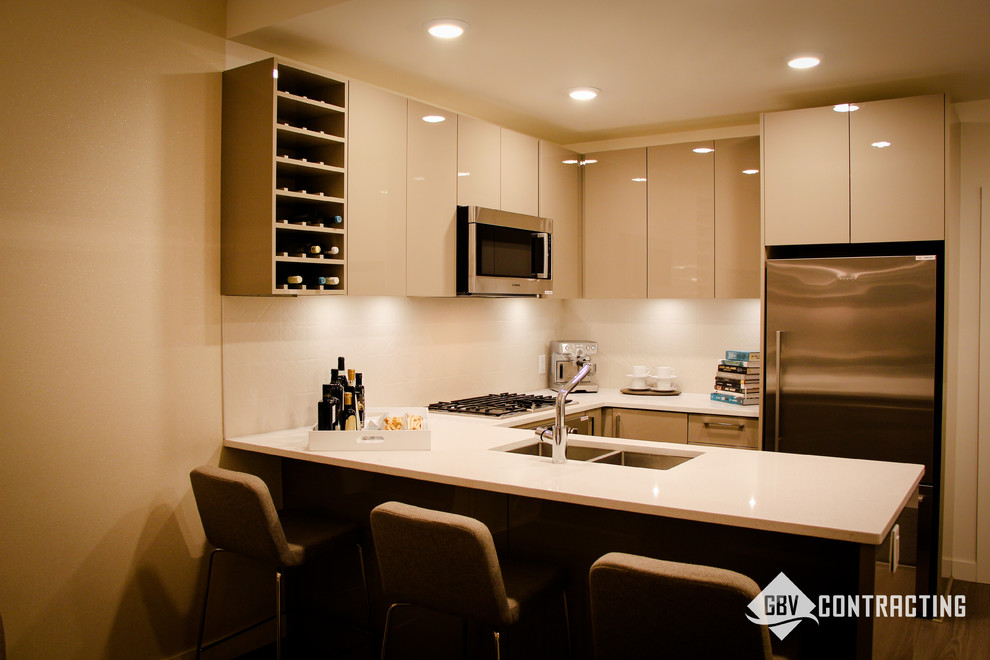 Inspiration for a small modern u-shaped eat-in kitchen remodel in Calgary with beige backsplash and an island