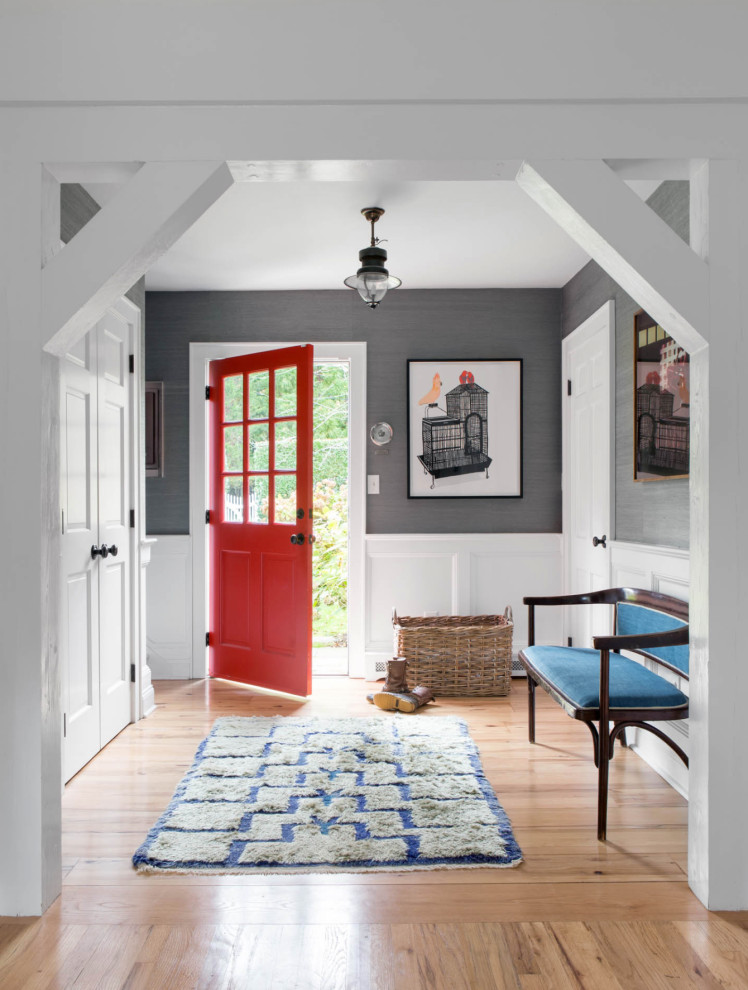 Photo of a beach style foyer in New York with grey walls, medium hardwood floors, a single front door, a red front door, brown floor, decorative wall panelling and wallpaper.